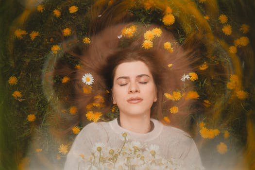 Woman with closed eyes surrounded by soft flowers in a circular frame, conveying calmness and gentle emotional grounding.