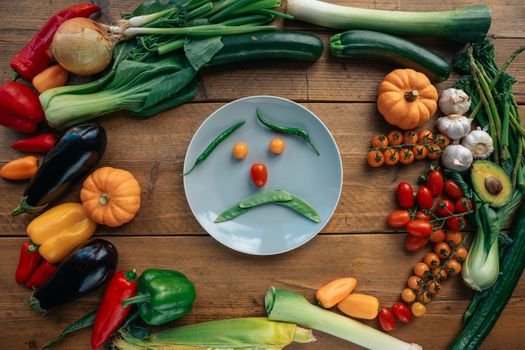 A sad face made from vegetables arranged on a plate, symbolizing low energy and fatigue.e.
