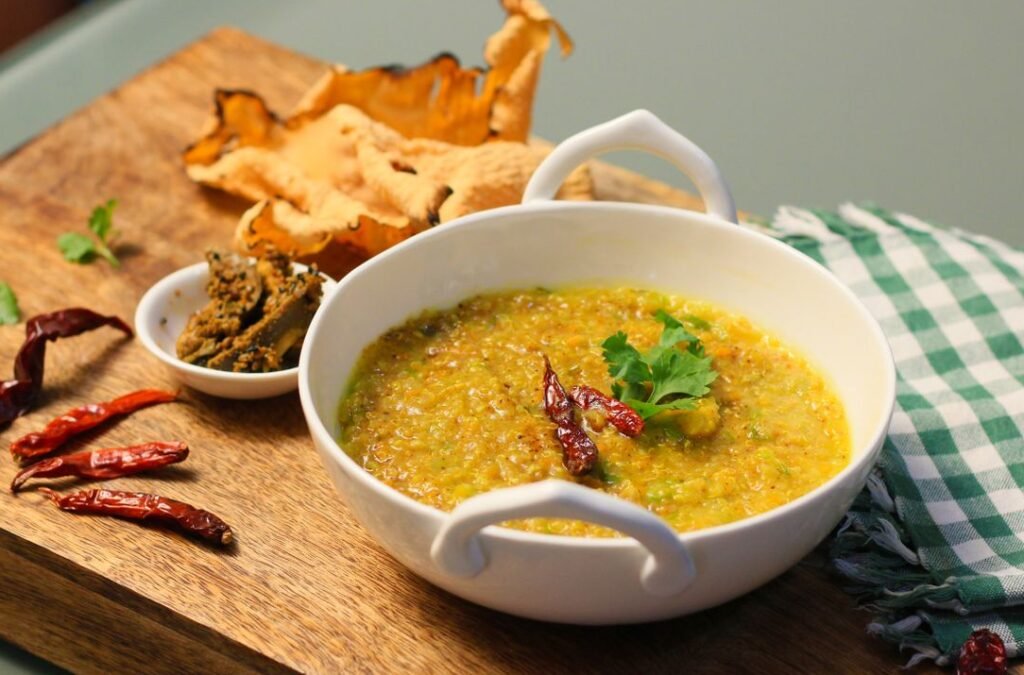 A khichdi dish served with chilies and papad, perfect for a spicy meal.